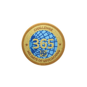 Patch with a gold background and blue centre that says 365 over the blue.  Around the edge says Challenge 365 Days of Geocaching.