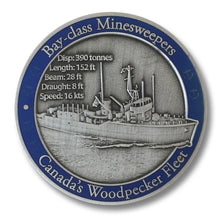 Front of coin in antique silver showing large 3D image of ship, with technical details and a blue translucent paint border. 