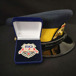 Blue velvet box with custom cut out for RCMP 150th coins sitting in front of an RCMP forage cap (on loan to us)