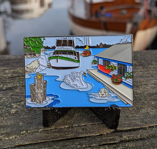 Rectangular coin with a dockside scene, with a seagull, swan, seal and a few boats