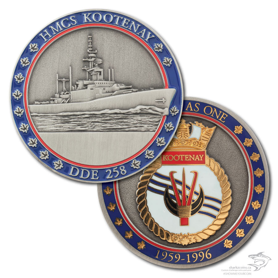 Both sides of the HMCS Kootenay coin are pictured.  The front has a 3D antique silver image of the with a red and blue border, the back is a 2 tone polished gold and antique silver with the ship's crest and the red and blue border.