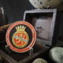 Front view of MacKenzie challenge coin in a display case.The coin displays the Mackenzie Ship crest surrounded by a border with the phrase "By Virtue and Valour" at the top, and "1962 to 1993" at the bottom