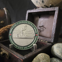 Back view of our HMCS Saskatchewan challenge coin in a display case. The coin displays the Saskatchewan Ship in the water with an anchor above it, all surrounded by a border with "HMCS SASKATCHEWAN" at the top, and "DDE 262" at the bottom