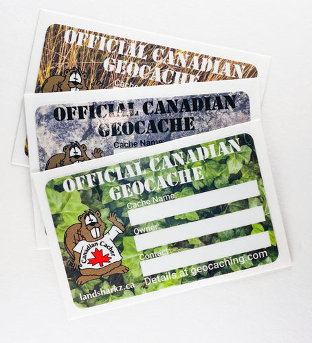 three geocaching stickers in prairie grass, stone and ivy. beaver dude's image is on the left and the areas to write the cache name, owner and contact details is on the right. The top says in stencil font: Official Canadian Geocache