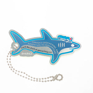 Opposite side of Landsharkz trackable tag.  A blue cartoon shark with the trackable code attached to a ball chain