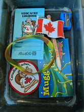 A geocache filled with various items, including a geocache logbook, bracelet, pencil, patch and the Canada Flag tag.