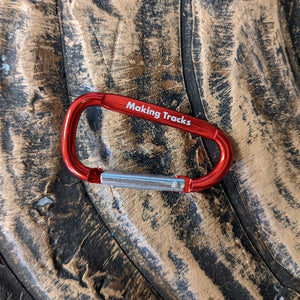 Small red carabiner with Making Tracks on side
