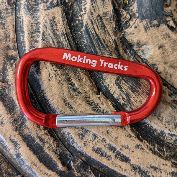 Large red carabiner with Making Tracks written on side