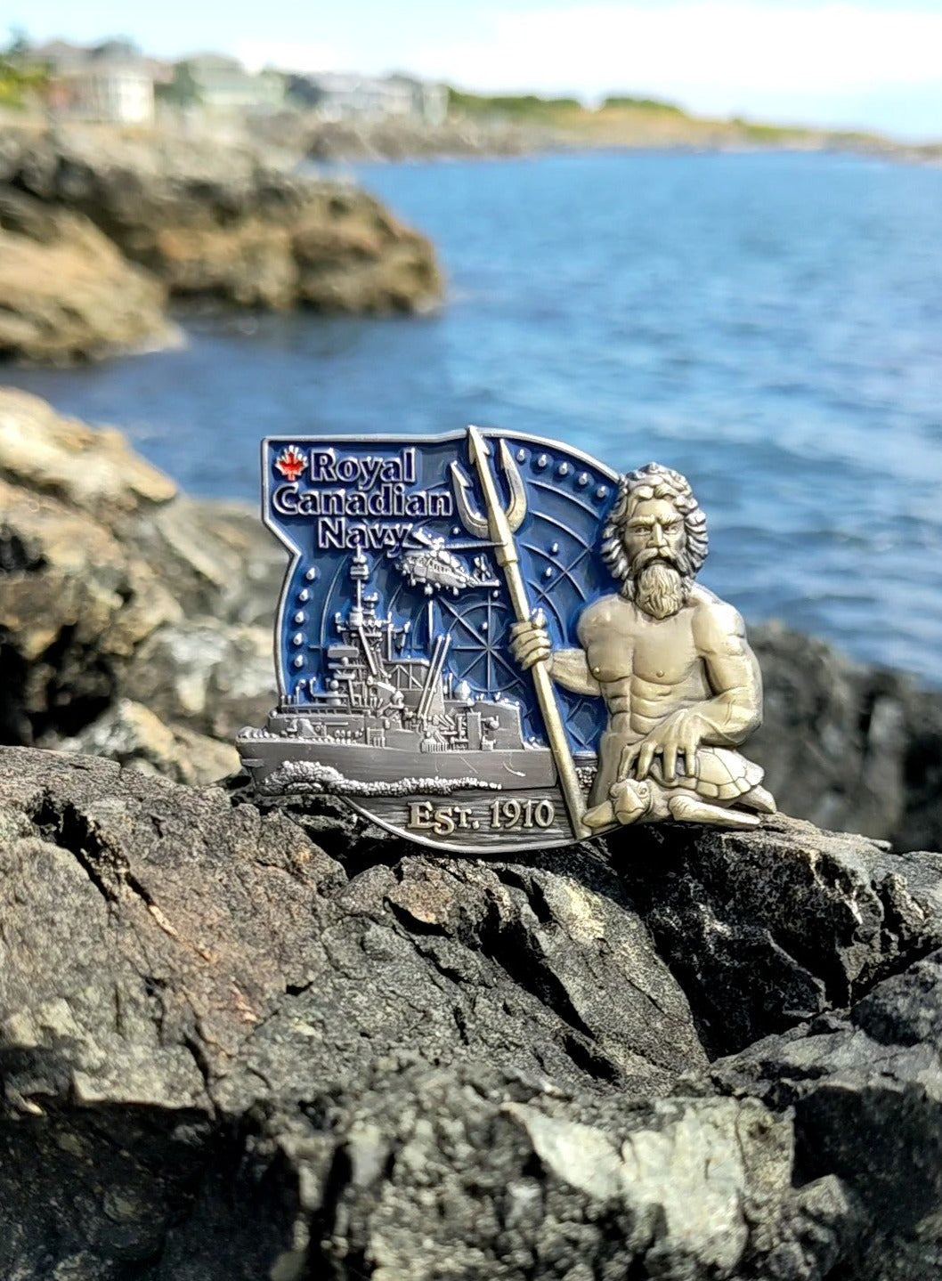 Royal Canadian Navy coin on rocks with antique bronze King Neptune and matte nickel ship and helicopter behind