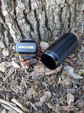 Close up of the black geocache with the lid off