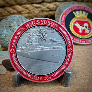 Back of the HMCS Yukon coin features the ship in satin nickel 3D relief with a ship's wheel in the sky above. DDE 263 is at the bottom. The border is painted red to match the colour in the crest.