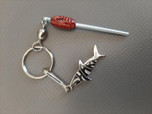 Silver Sharkz logo on a keychain with a nano log roller with a red bead