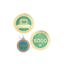 Milestone geocoin in gold with turquoise paint for your 8000th find.  Front and back pictured, as well as the matching tag.