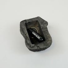 Micro geocache inside flat bottom of fake rock