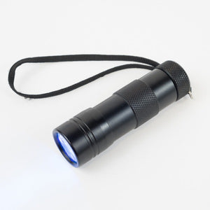 Black Ultra Violet LED Flashlight with cord switched on