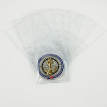 Ten clear PVC pouches pictured, one holding a Navy challenge coin